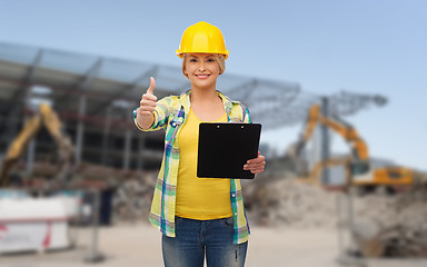 Image showing smiling woman in helmet with clipboard