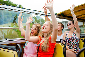 Image showing group of smiling friends traveling by tour bus