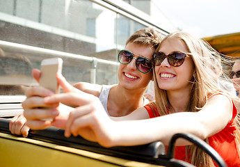 Image showing smiling couple with smartphone making selfie