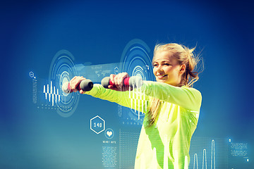 Image showing sporty woman with light dumbbells outdoors