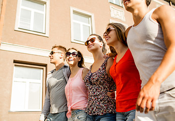 Image showing group of smiling friends walking in city