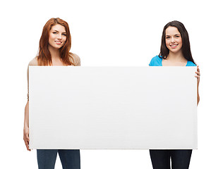 Image showing two smiling young girls with blank white board