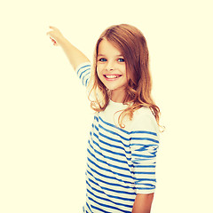 Image showing smiling girl pointing at virtual screen