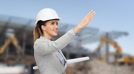 Image showing smiling architect in helmet with blueprint