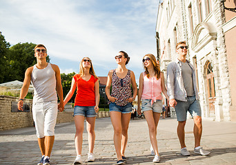 Image showing group of smiling friends walking in city