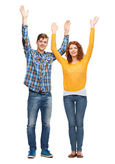 Image showing smiling teenagers with raised hands