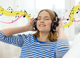 Image showing smiling young girl in headphones at home