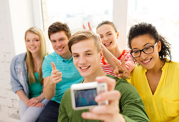 Image showing five smiling students taking picture with camera