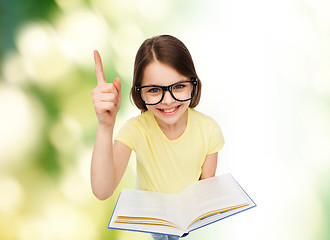 Image showing smiling little girl in eyeglasses with book