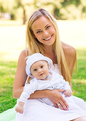 Image showing happy mother with little baby sitting on blanket