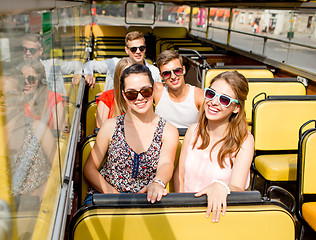 Image showing group of smiling friends traveling by tour bus