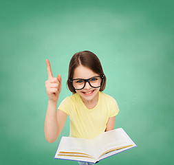 Image showing smiling little girl in eyeglasses with book