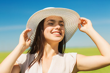 Image showing smiling young woman in straw hat outdoors