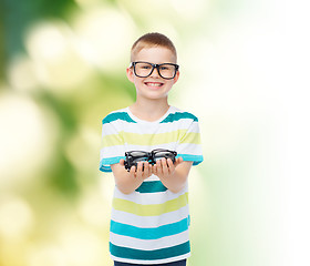 Image showing smiling boy in eyeglasses holding spectacles