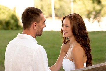 Image showing smiling couple sitting on bench in park