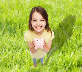 Image showing beautiful little girl with piggy bank