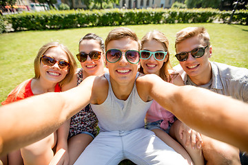 Image showing group of smiling friends making selfie in park