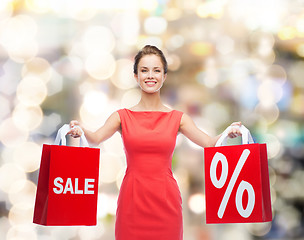 Image showing young woman in red dress with shopping bags