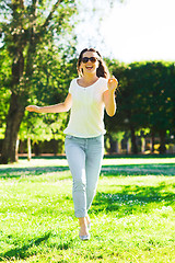 Image showing smiling young woman with sunglasses in park