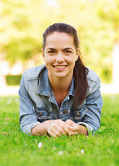 Image showing smiling young girl lying on grass