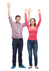 Image showing smiling teenagers with raised hands