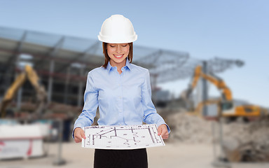 Image showing businesswoman in white helmet with blueprint