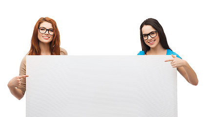 Image showing two smiling girls with eyeglasses and blank board