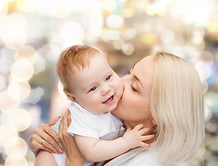 Image showing happy mother kissing smiling baby