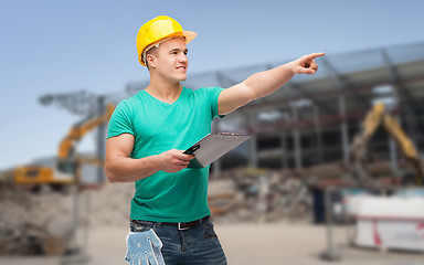 Image showing smiling man in helmet with clipboard