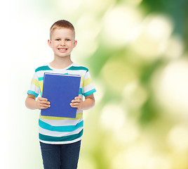 Image showing smiling little student boy with blue book