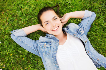 Image showing smiling young girl lying on grass