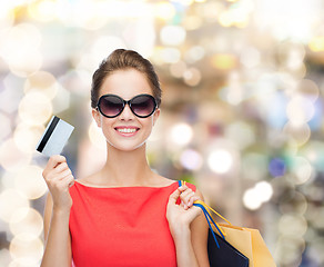 Image showing smiling woman with shopping bags and plastic card