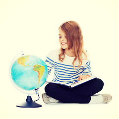 Image showing child looking at globe and holding book
