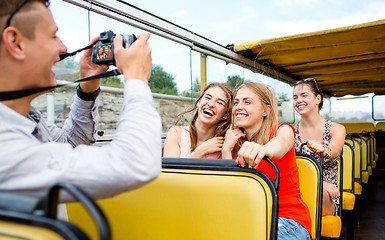 Image showing laughing friends with camera traveling by tour bus