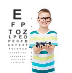 Image showing smiling boy in eyeglasses holding spectacles