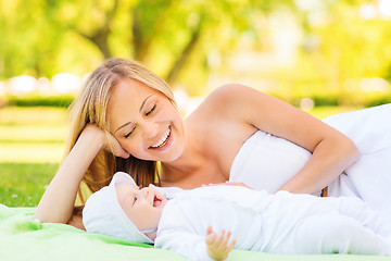 Image showing happy mother lying with little baby on blanket