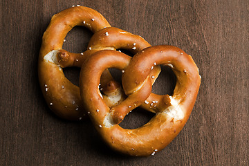 Image showing Two typical bavarian pretzel on a brown background