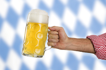 Image showing Man in traditional Bavarian shirt holds mug of beer