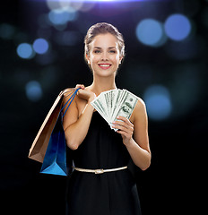 Image showing smiling woman in dress with shopping bags
