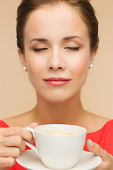 Image showing smiling woman in red dress with cup of coffee