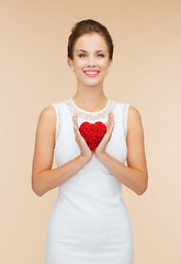 Image showing smiling woman in white dress with red heart