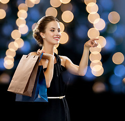 Image showing smiling woman in dress with shopping bags