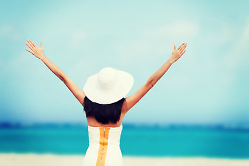 Image showing girl with hands up on the beach