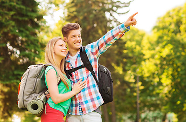 Image showing smiling couple with backpacks in nature