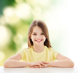 Image showing beautiful little girl sitting at table