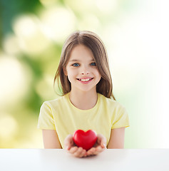 Image showing beautiful little girl sitting at table