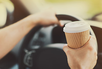 Image showing man drinking coffee while driving the car