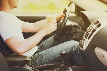 Image showing man drinking coffee while driving the car