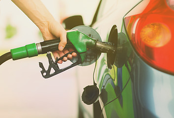 Image showing man pumping gasoline fuel in car at gas station