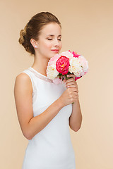 Image showing smiling woman in white dress with bouquet of roses